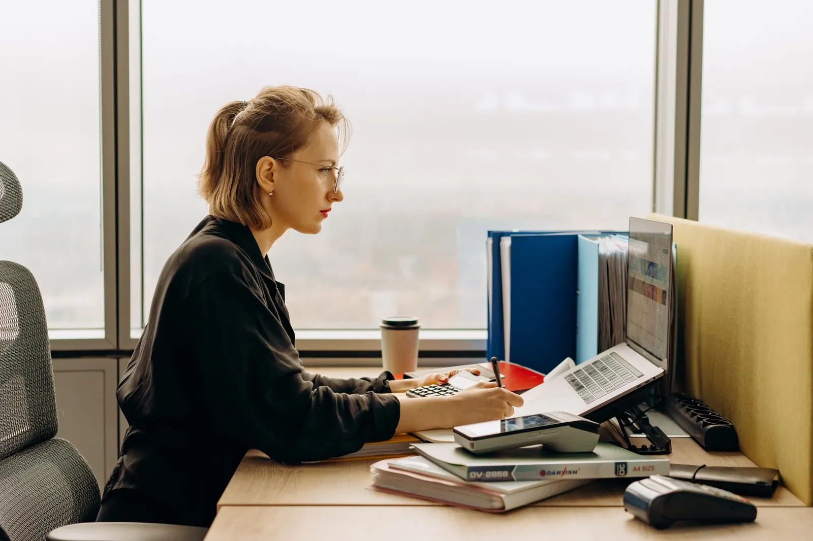 An accountant working through paperwork at her desk